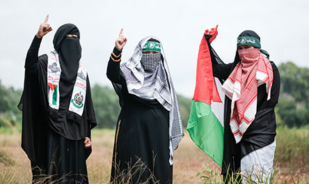 A crowd of angry Muslims marching and holding signs that say Jihad and Islam will dominate the world.